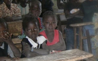 Kinder in Afrika vor Schulbank ohne Stifte